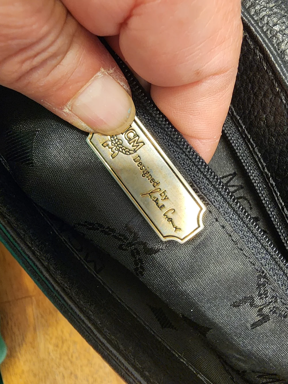 vintage MCM black pebbled leather studded crossbody bag featuring a front plaque